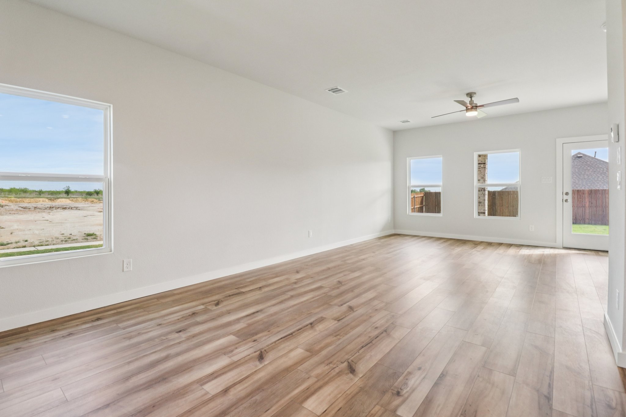 A room with a wood floor and a wood floor with a window.