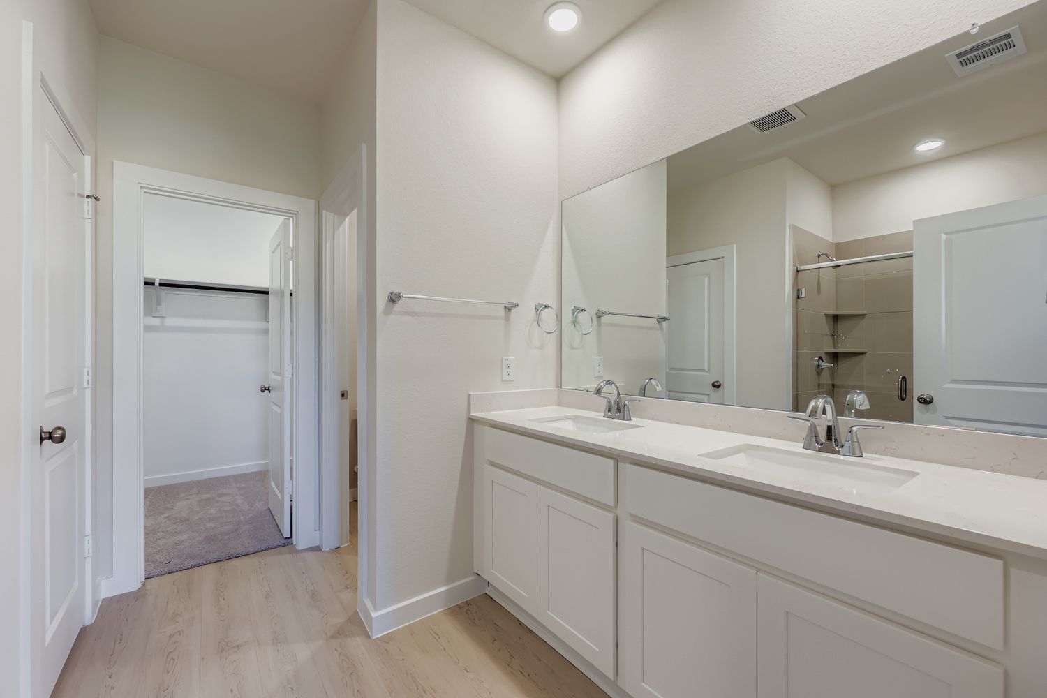 A bathroom with white cabinets.