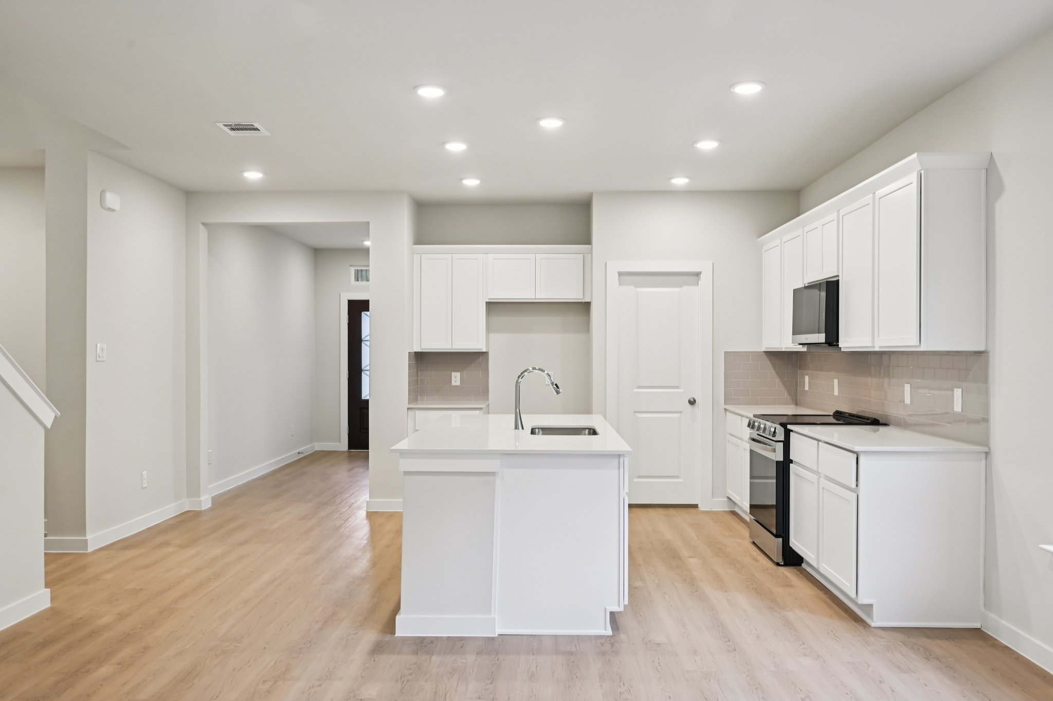 A kitchen with white cabinets.
