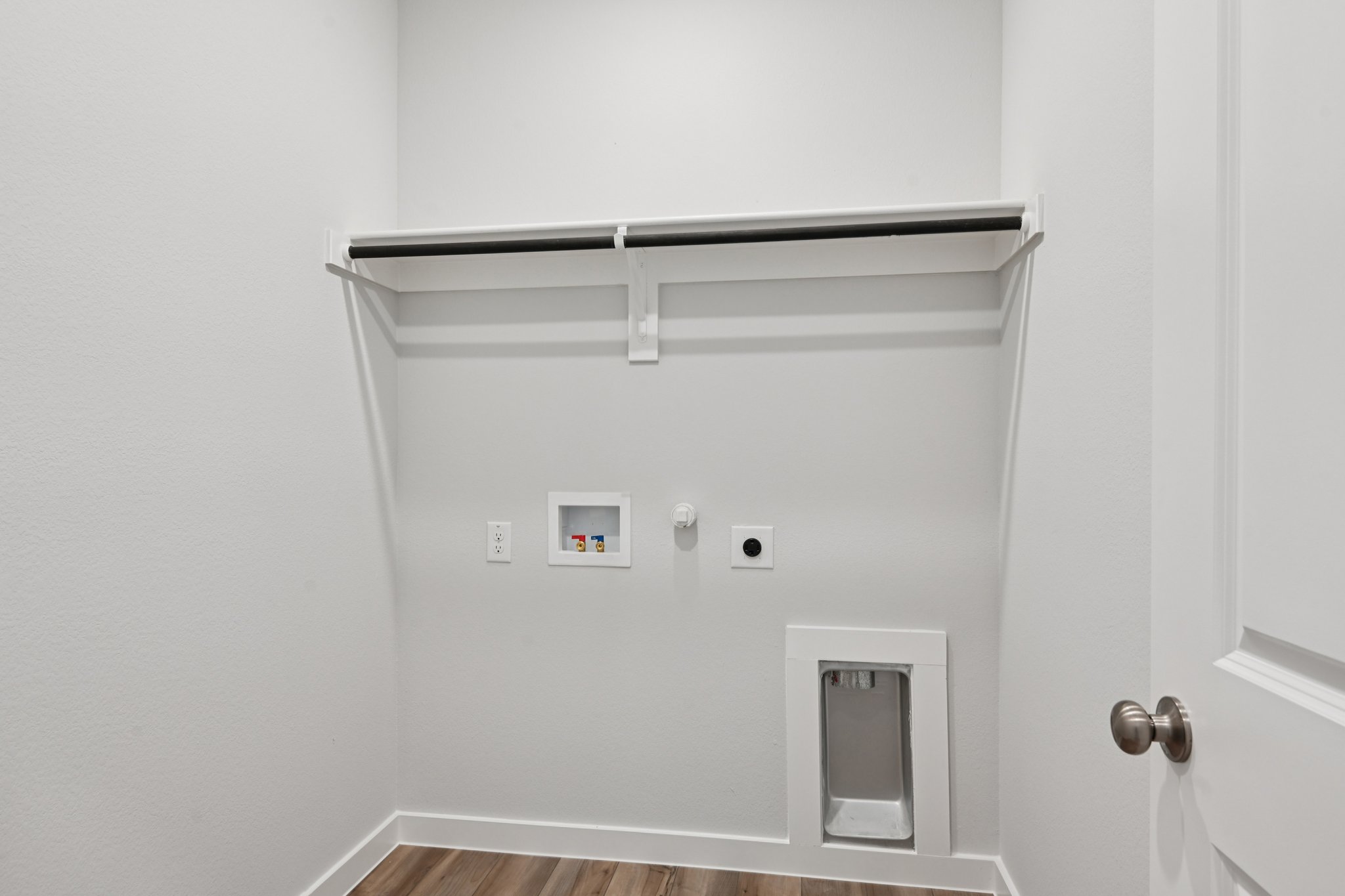 A white wall with a light switch.