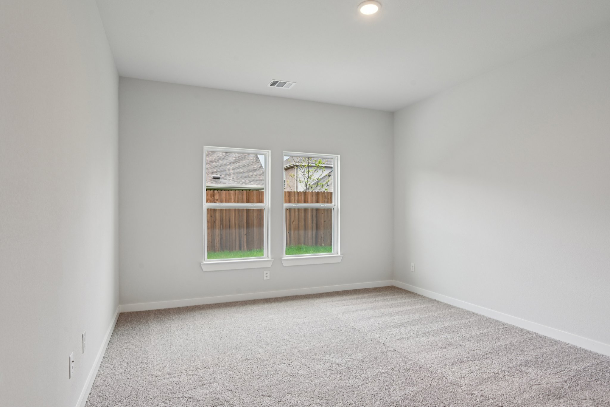 A room with a window and carpet.