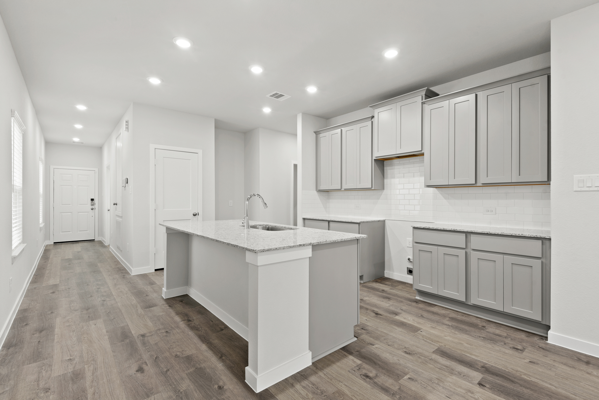 A kitchen with white cabinets.