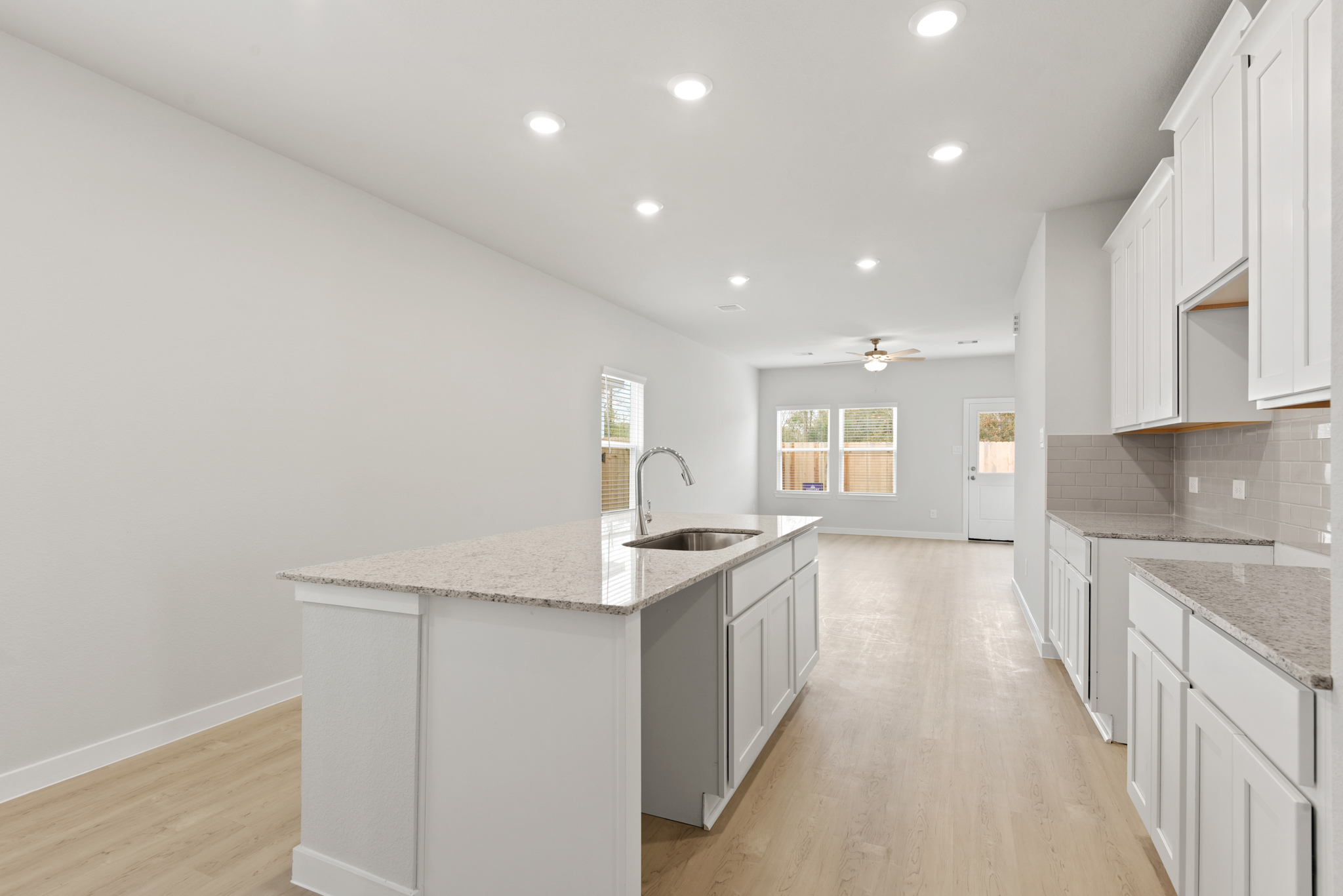 A kitchen with white cabinets.