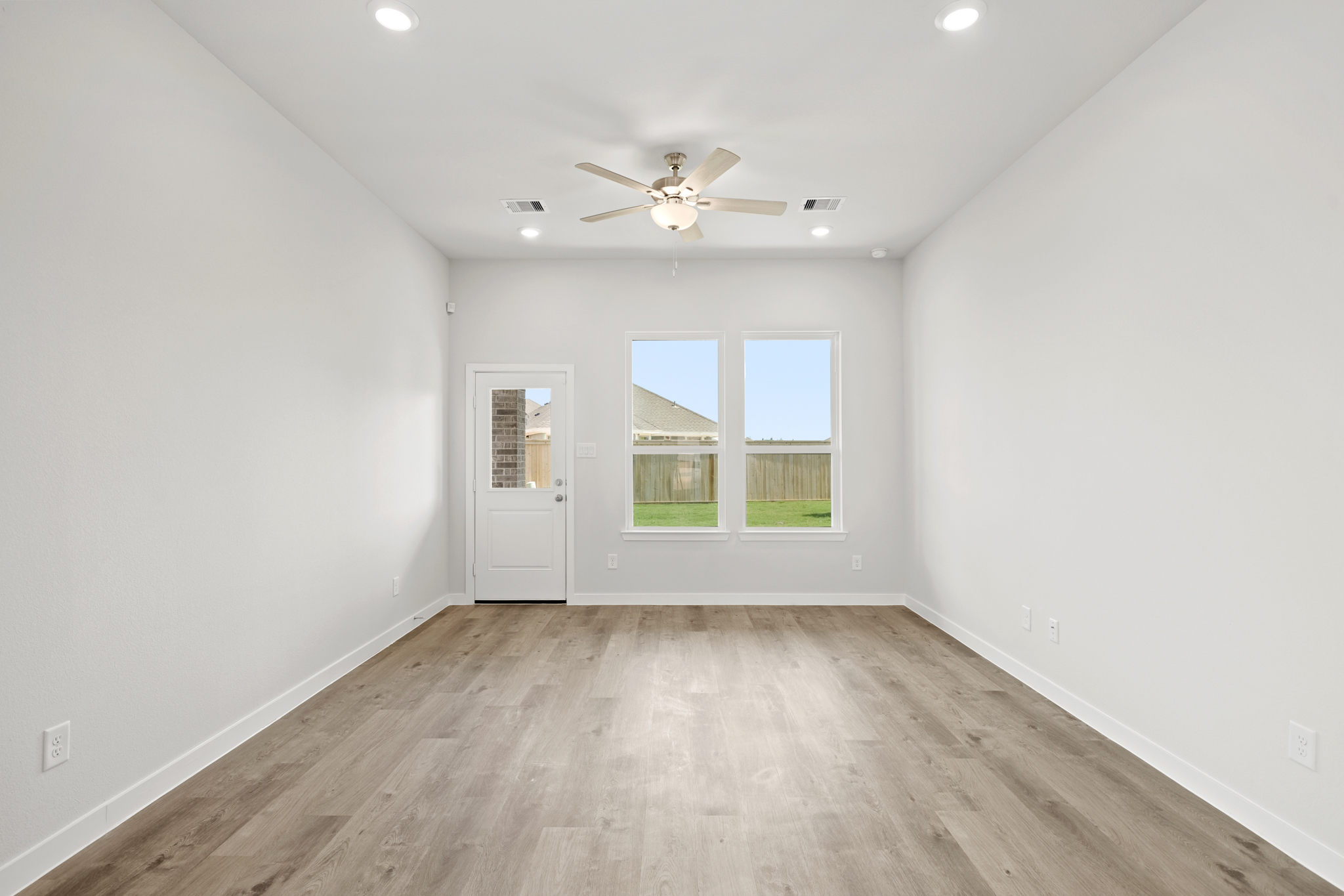 A room with a wood floor and a ceiling fan.