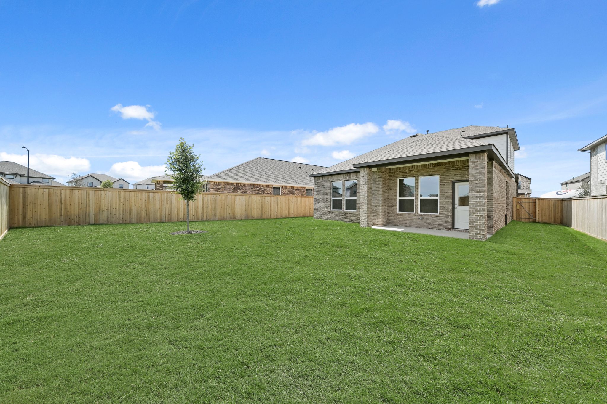 A large green lawn in front of a house.