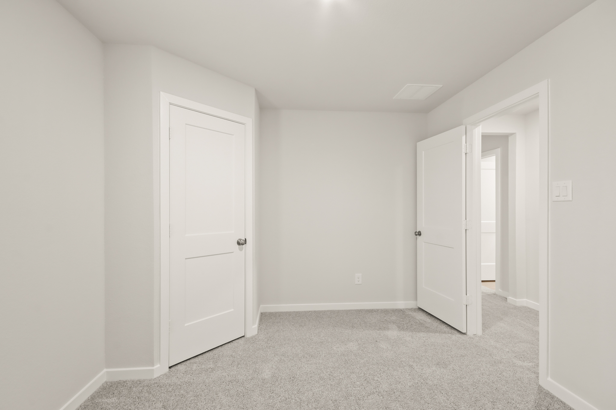 A hallway with white doors.