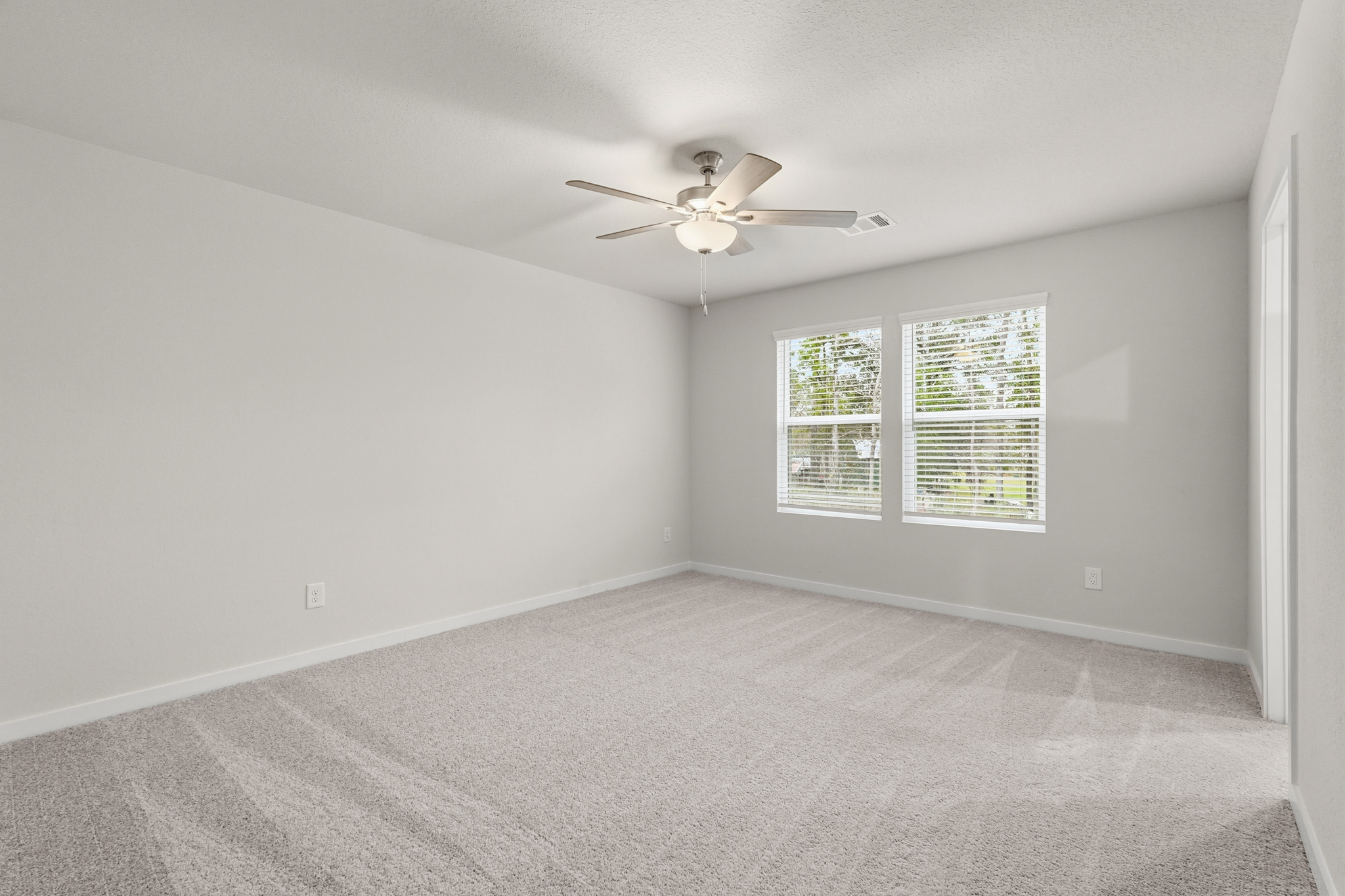 A room with a ceiling fan and a window.