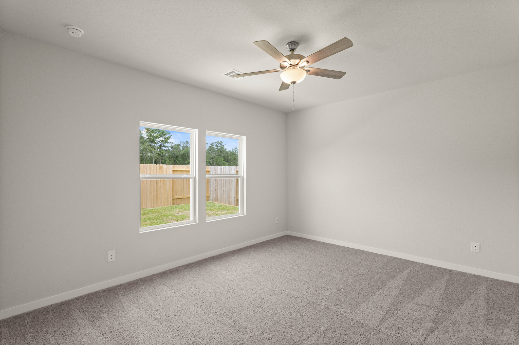 A room with a ceiling fan and a window.