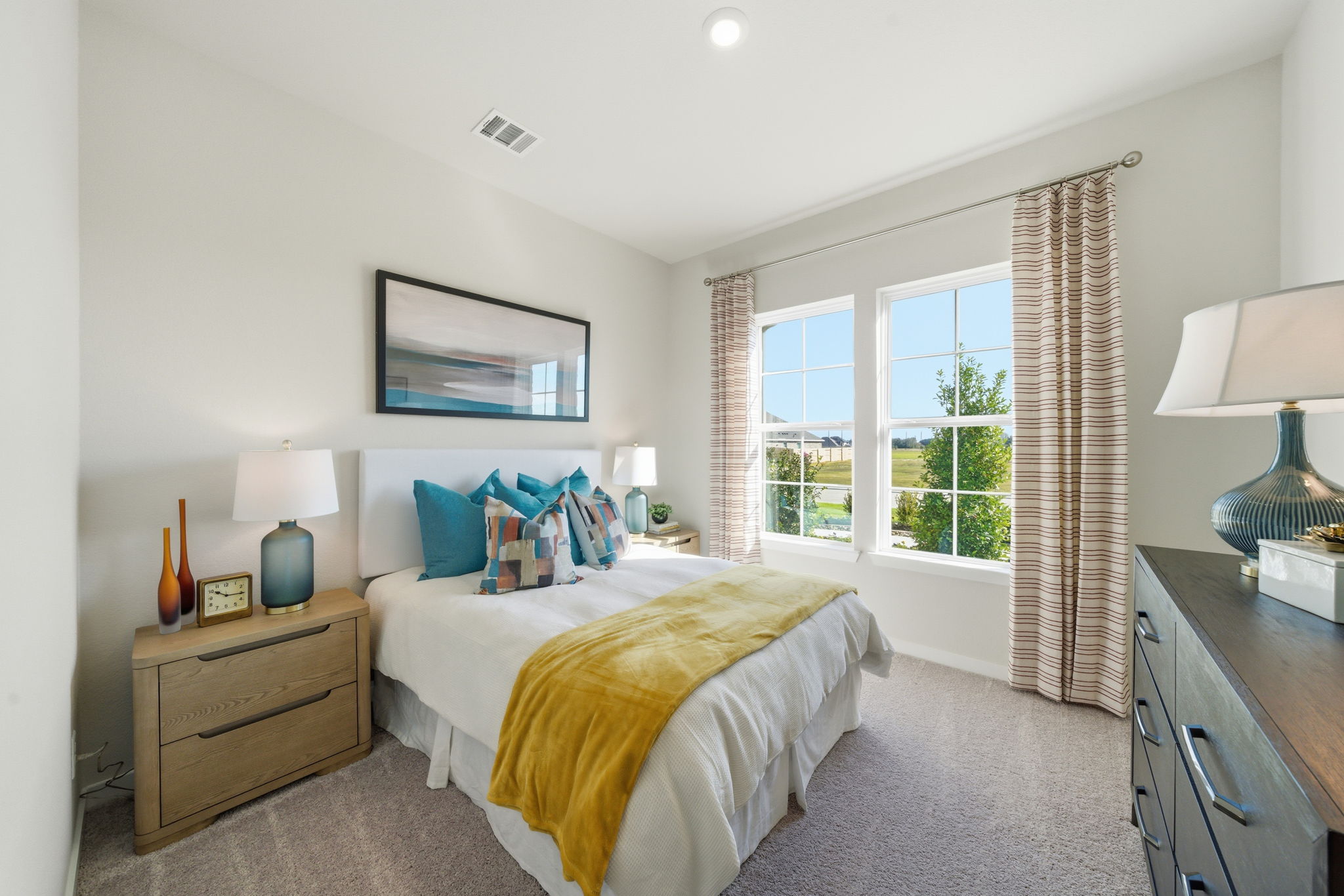 A bedroom with a bed and lamps.