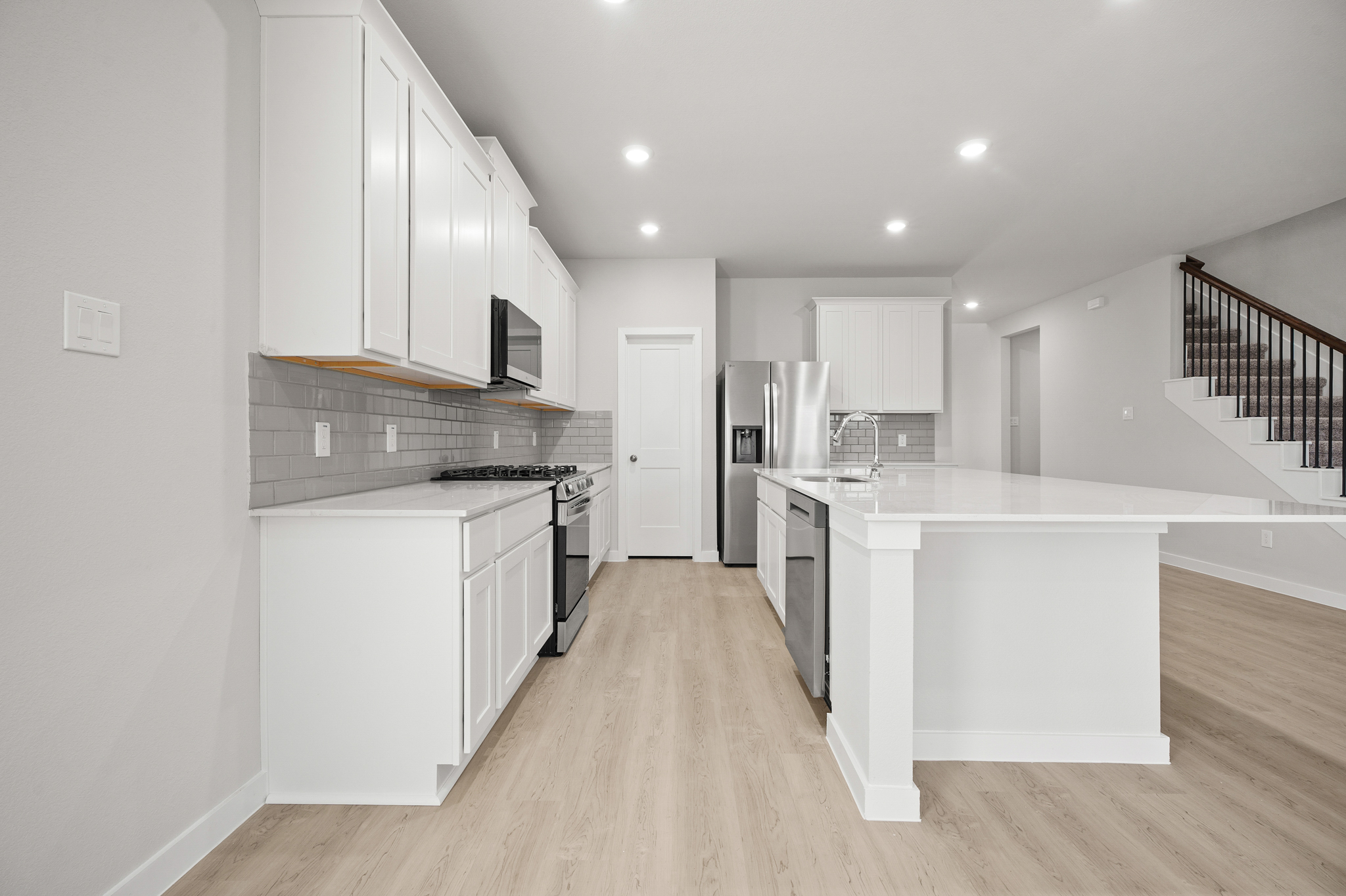 A kitchen with white cabinets.