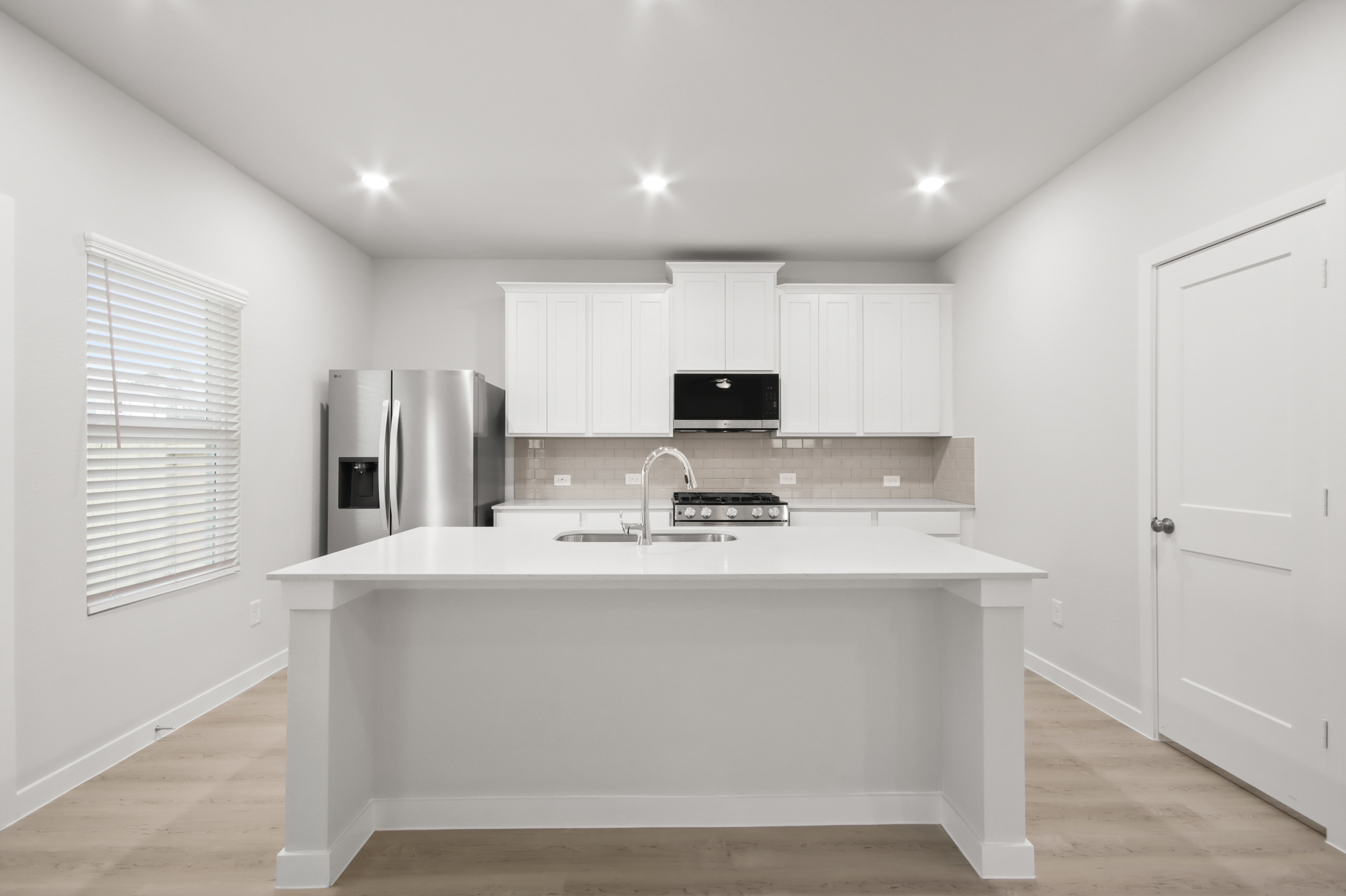 A kitchen with white cabinets.