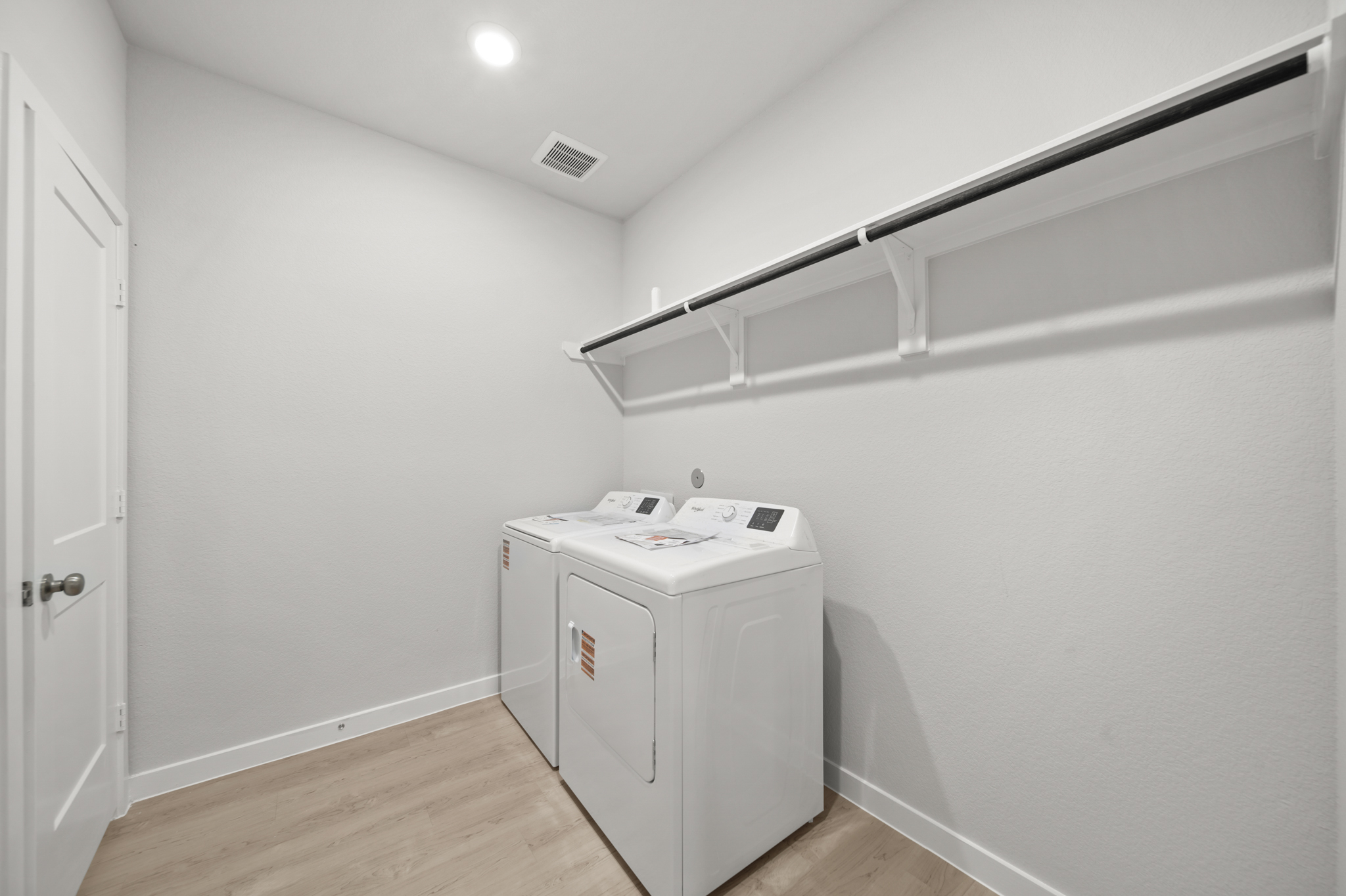 A white room with a white shelf and a white wall.