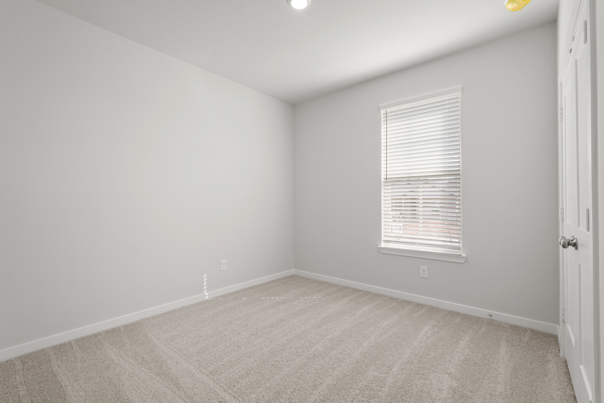 A room with a carpet and a window.