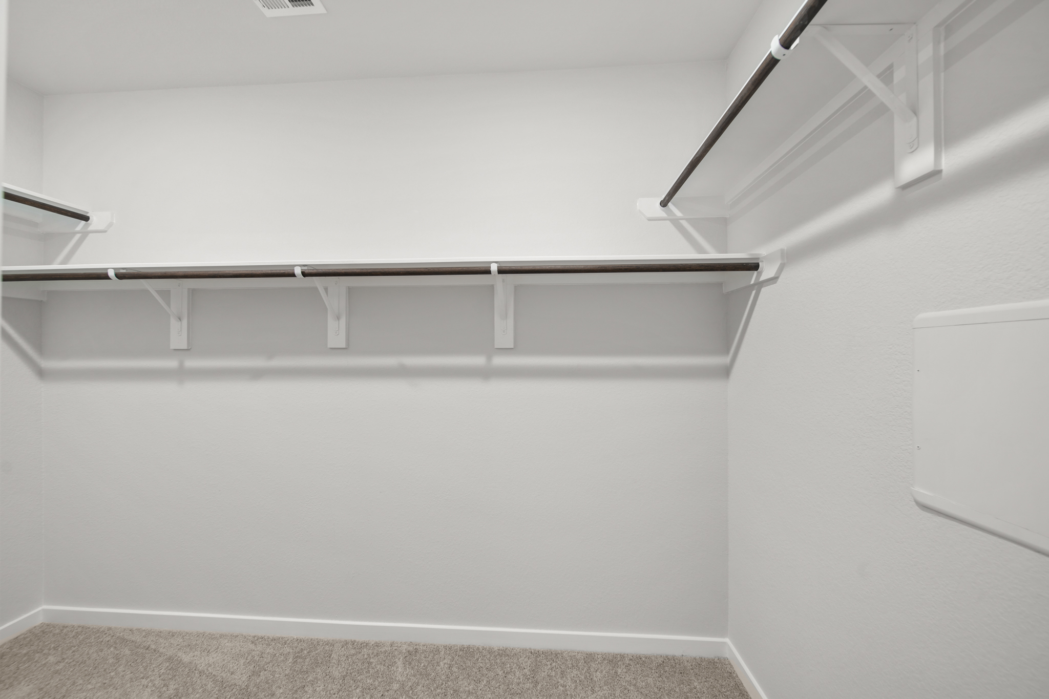 A white wall with a metal bar.