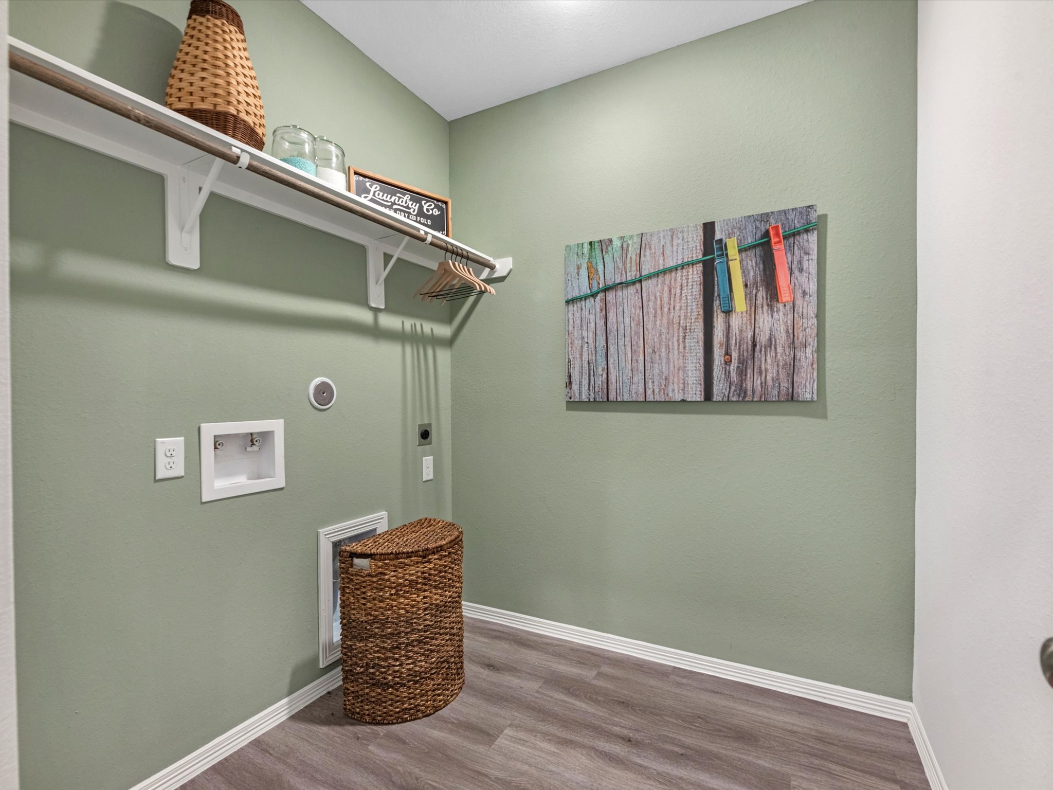 A room with a shelf and a basket on the wall.