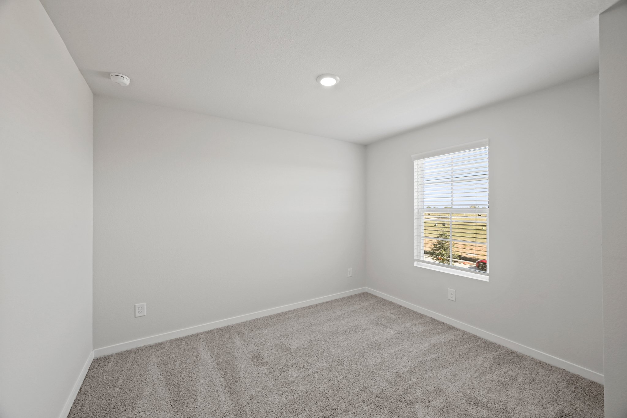 A room with a window and a carpet.