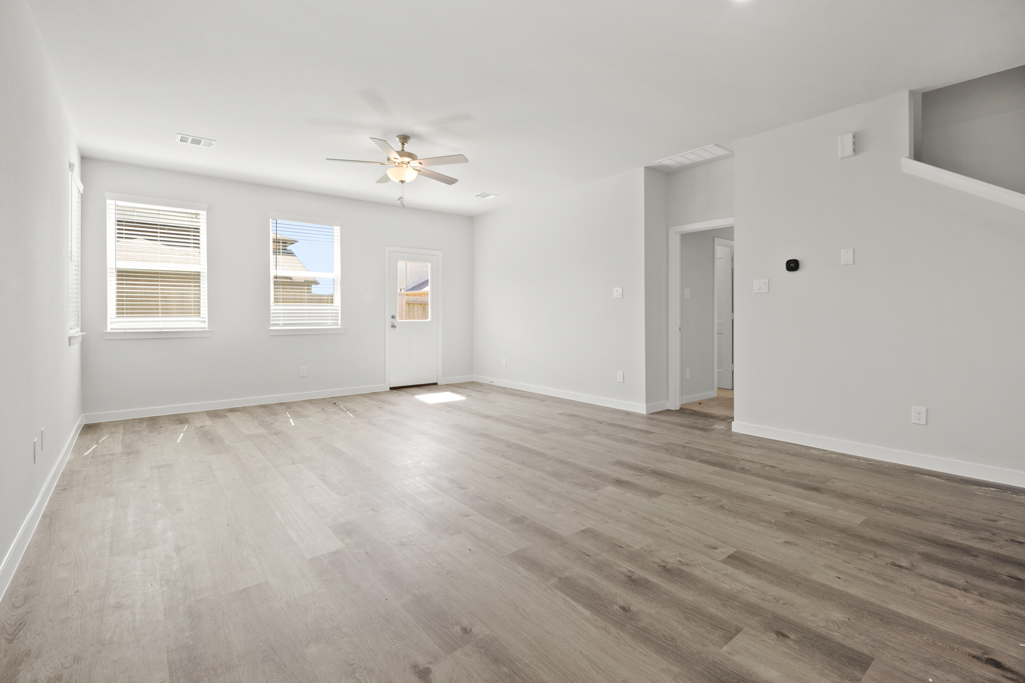 A room with a wood floor and a ceiling fan.
