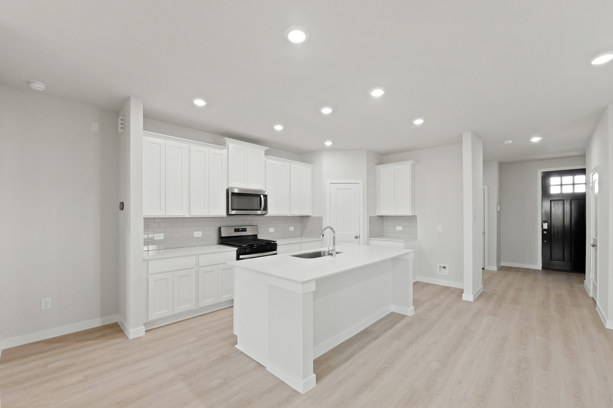 A kitchen with white cabinets.