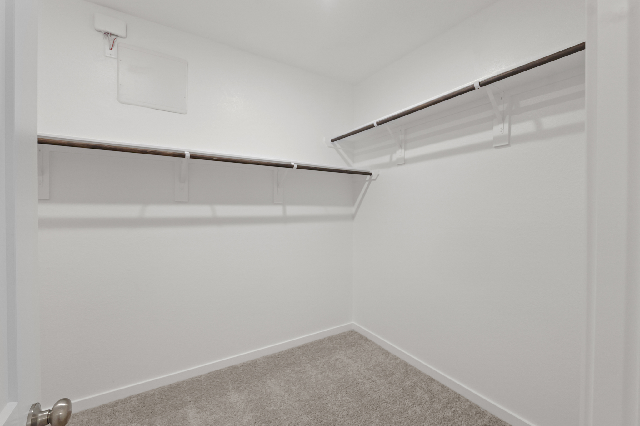 A white wall with a metal bar.