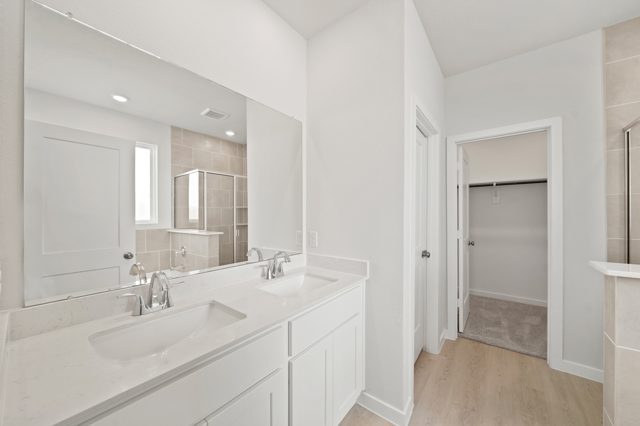 A bathroom with white cabinets.
