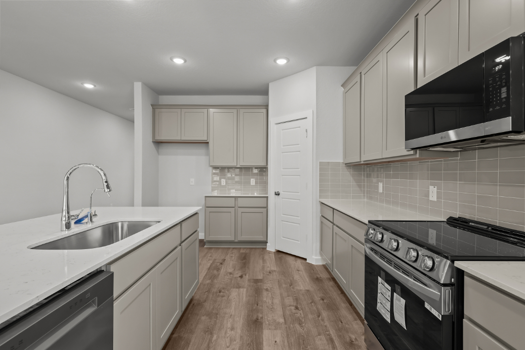 A kitchen with white cabinets.