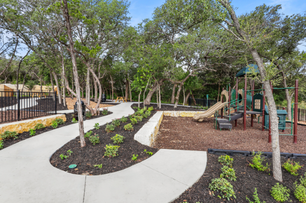 A playground with trees and a slide.