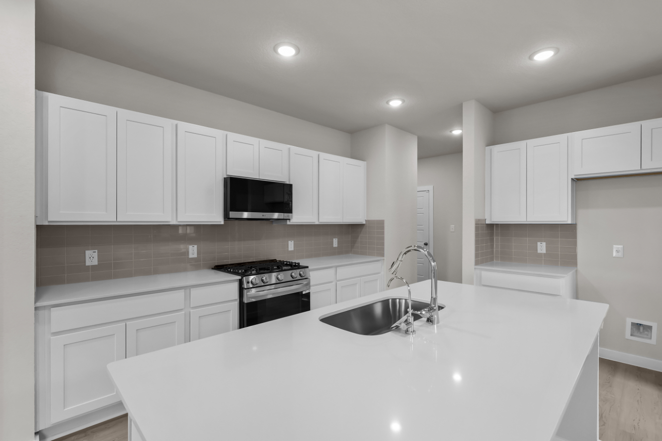 A kitchen with white cabinets.
