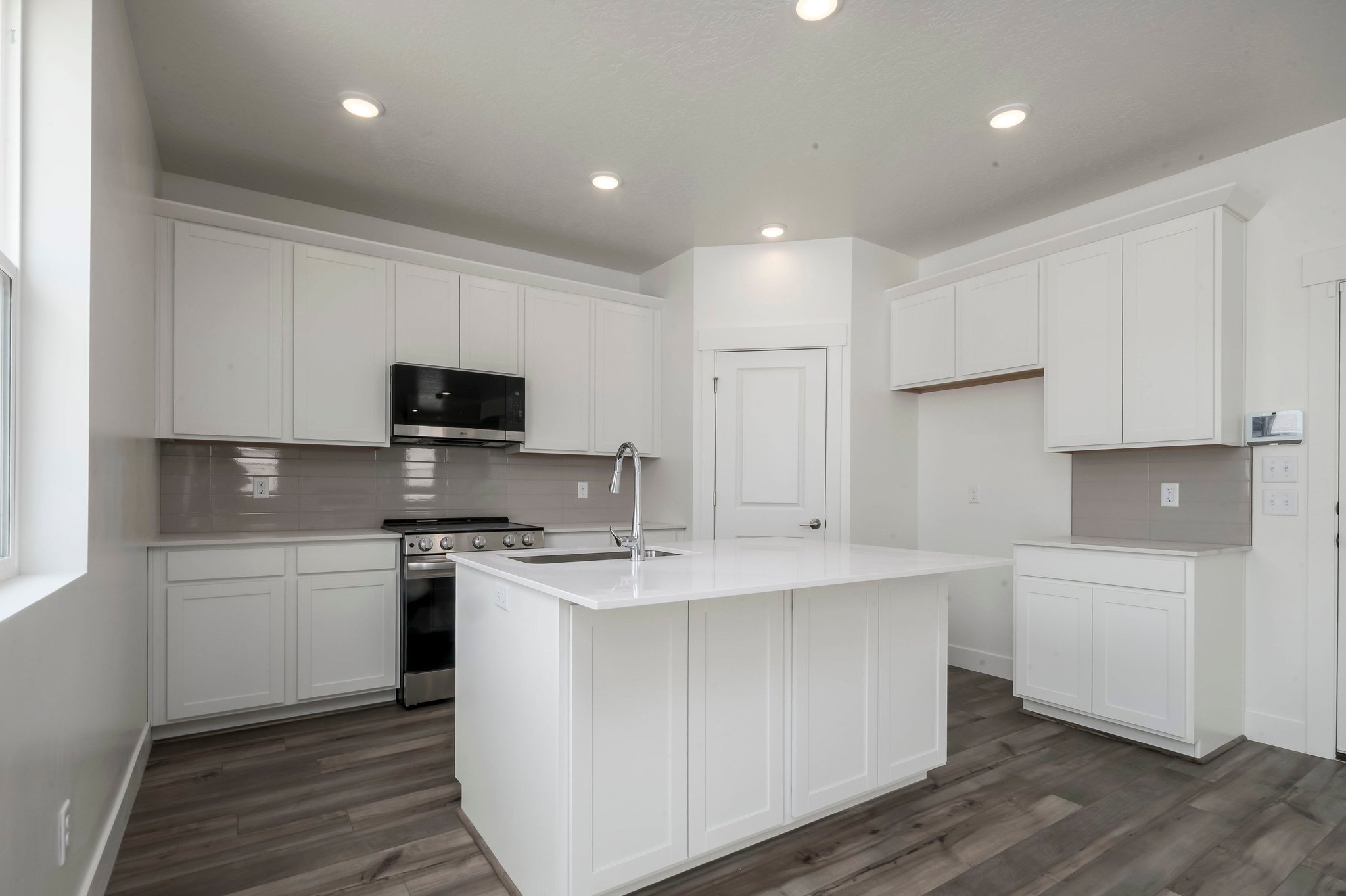 A kitchen with white cabinets.