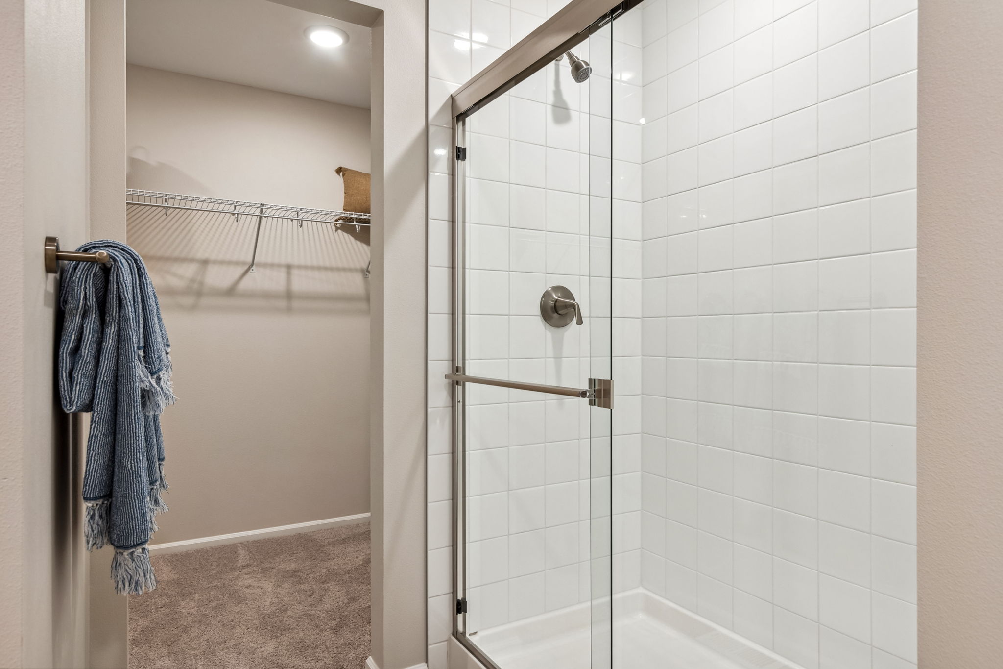 A shower with a towel on the wall.