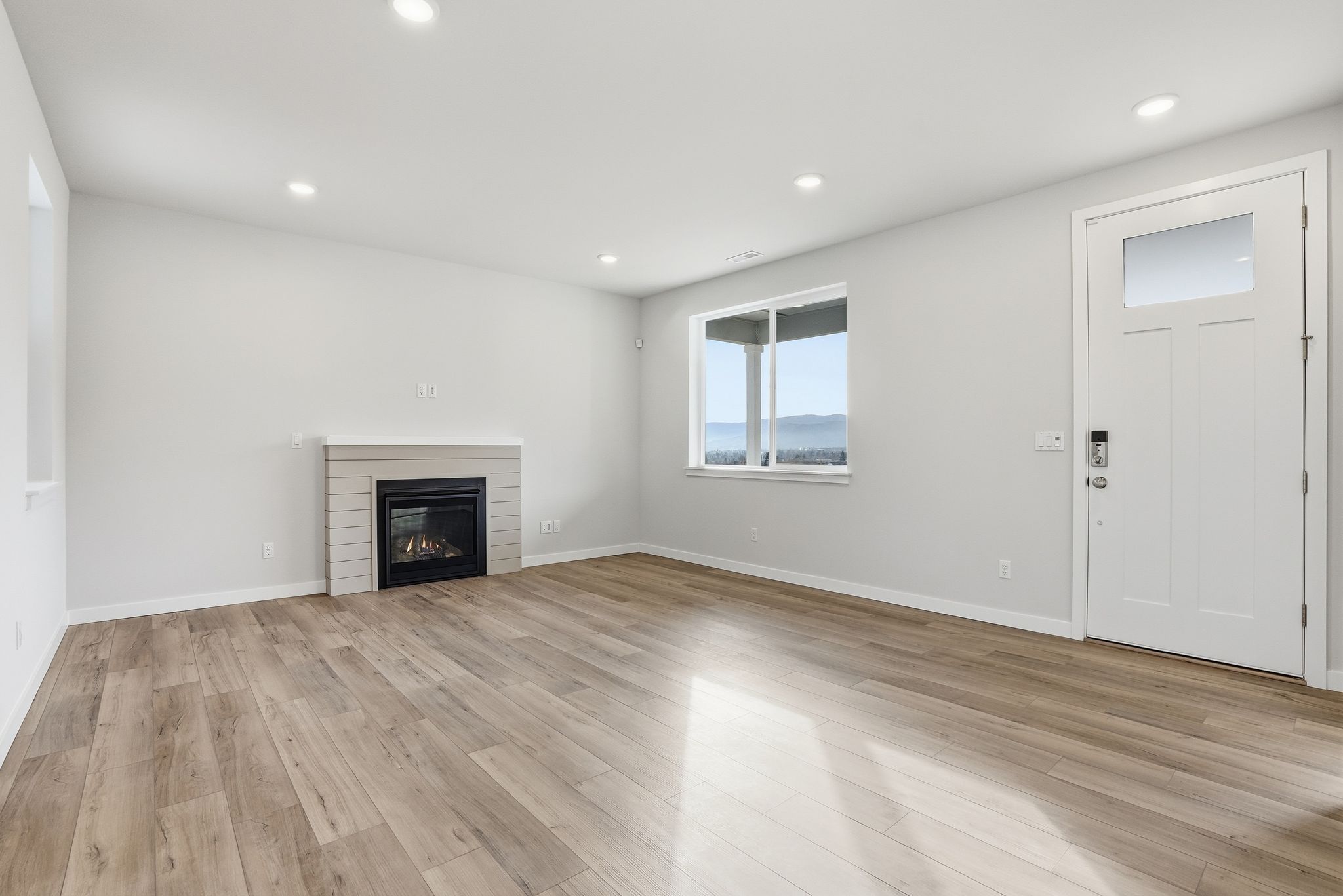 A room with a fireplace and a wood floor.