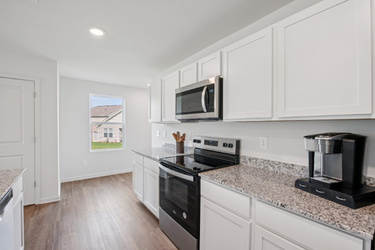 A kitchen with white cabinets.