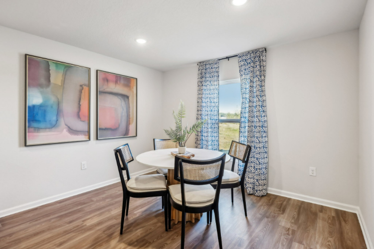 A dining room with a table and chairs.