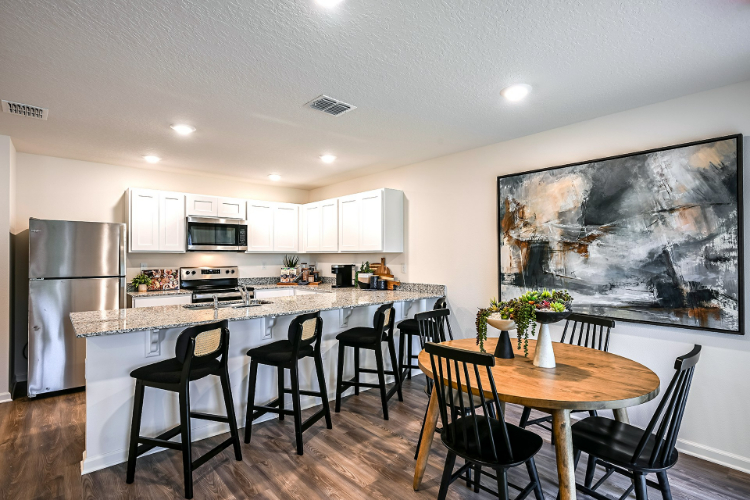 A kitchen with a dining table and chairs.