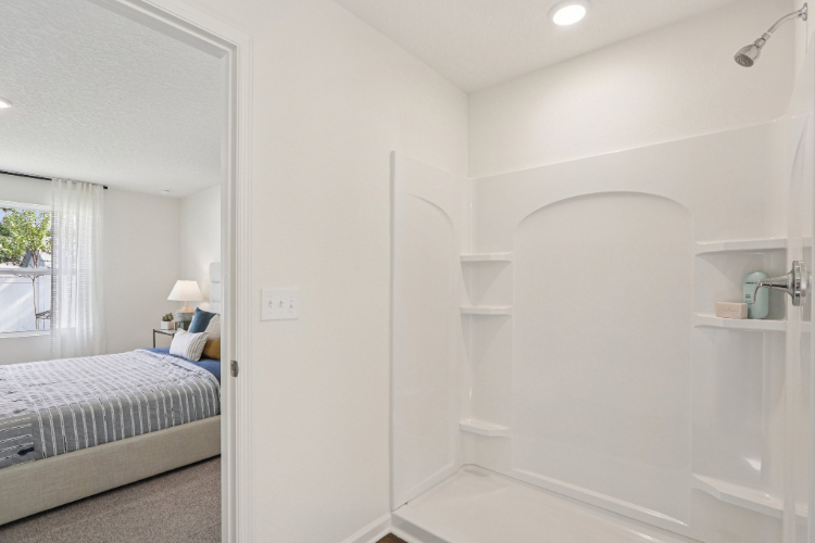 A bathroom with a bathtub and a bed.