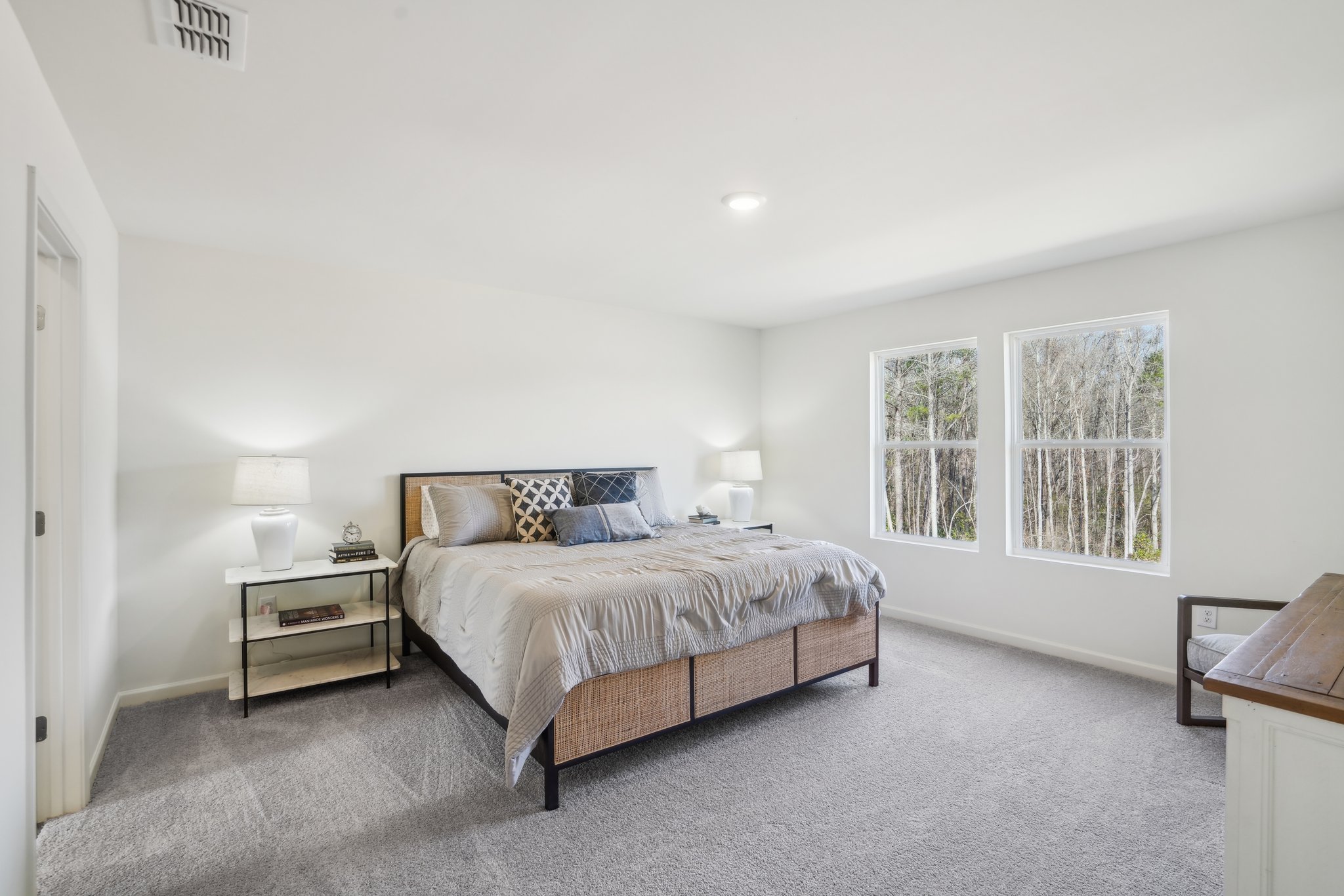 A bedroom with a bed and lamps.