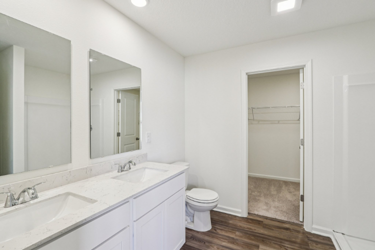 A bathroom with a toilet sink and mirror.