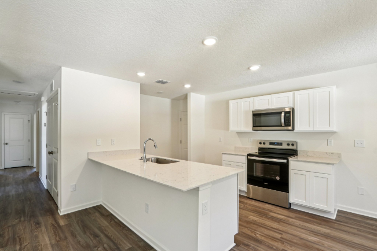 A kitchen with white cabinets.