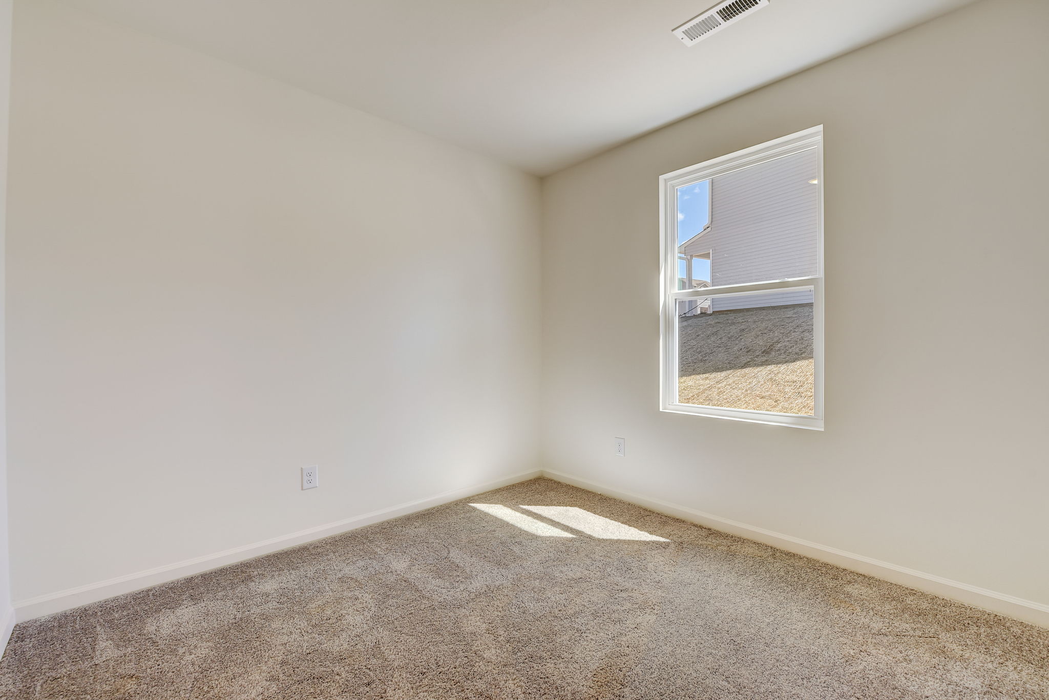 A room with a window and carpet.
