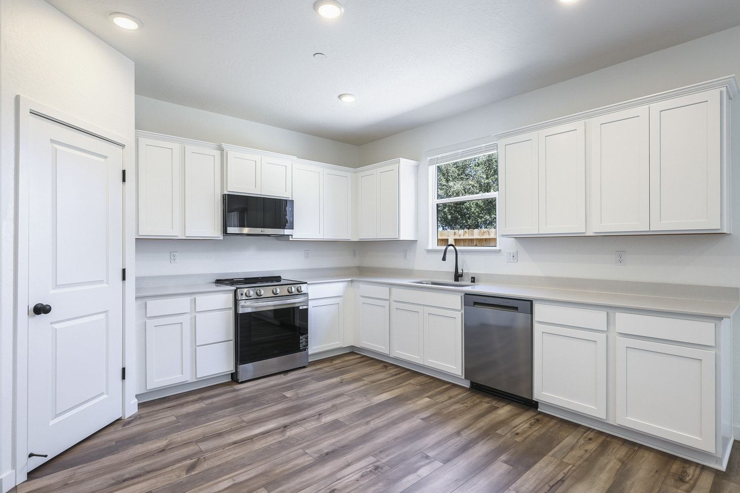 A kitchen with white cabinets.