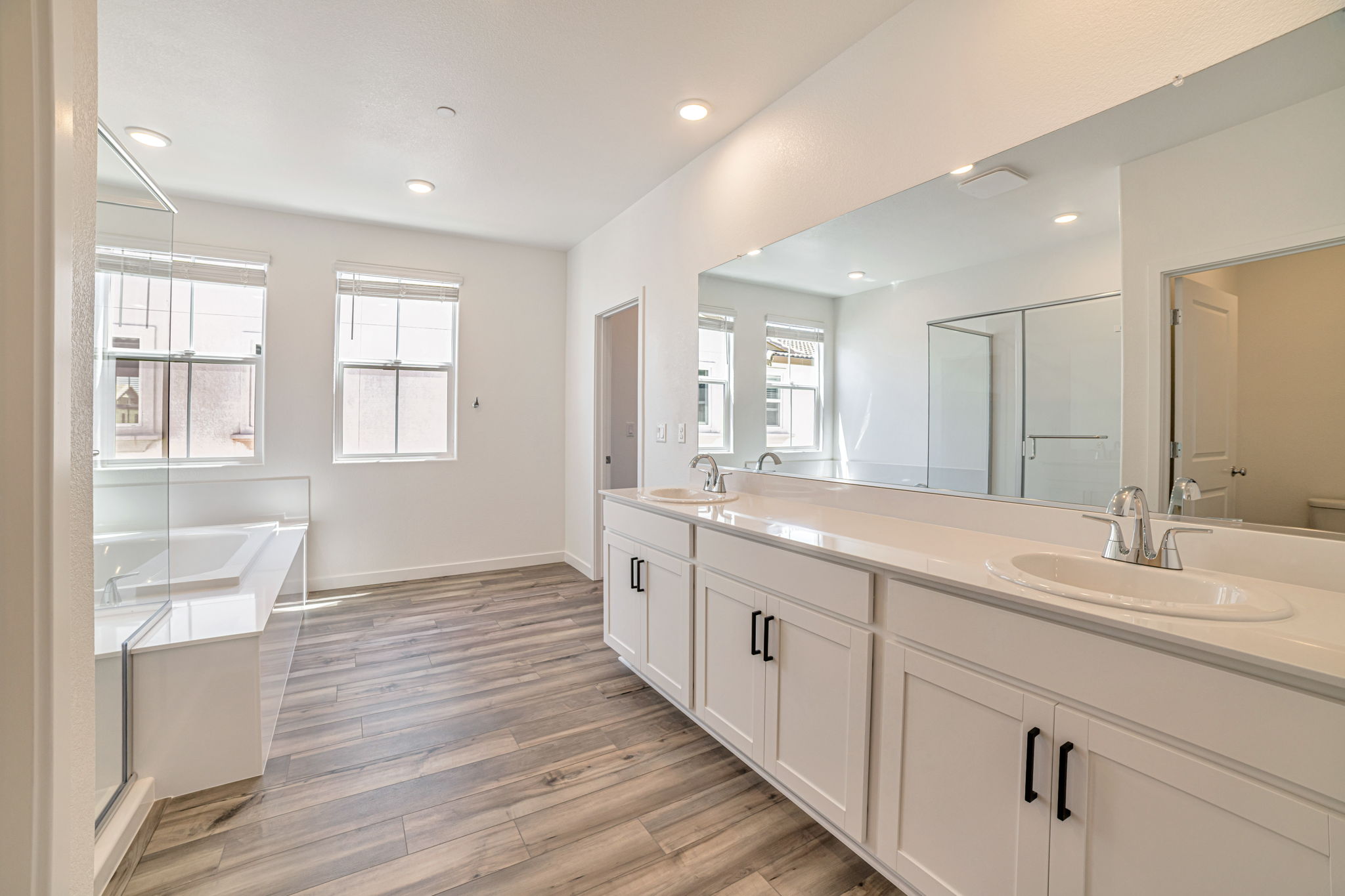 A bathroom with white cabinets.